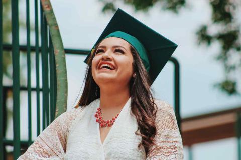 Woman with graduation cap looking at the sky